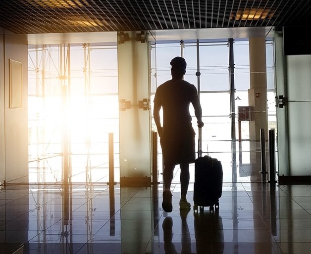 Un homme tenant sa valise dans un aéroport